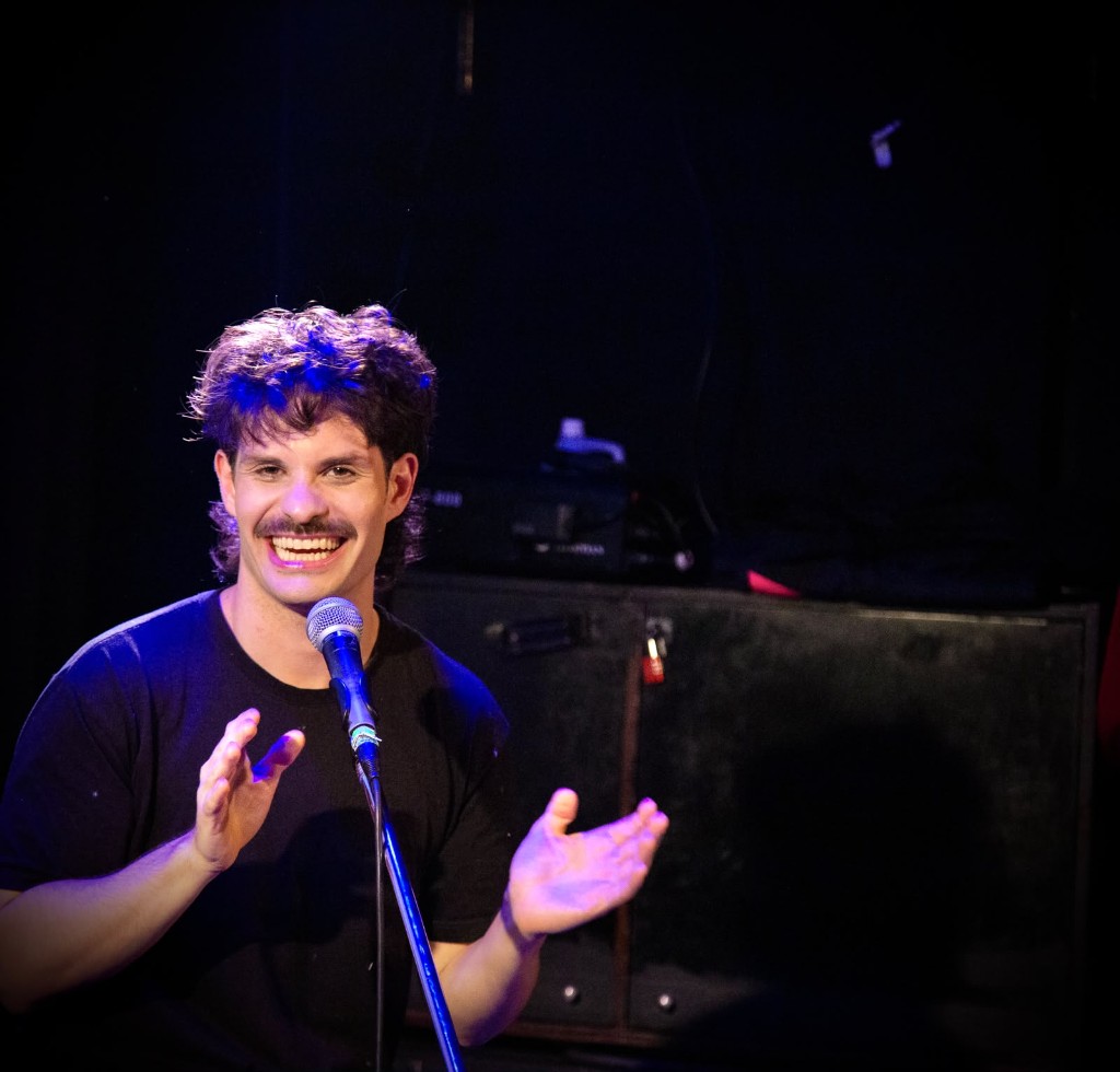 Uno de Nenasas al micrófono, sonriendo en el escenario